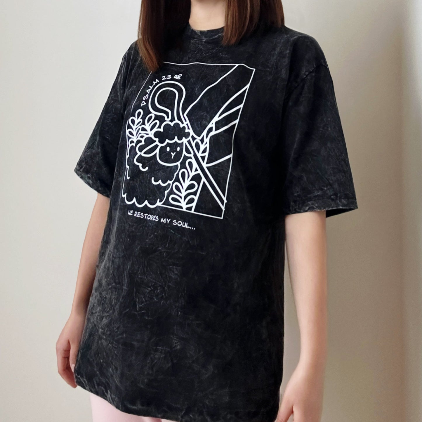 model wearing oversize t-shirt in stone wash color with a print of a sheep following the shepherd